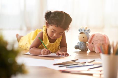 Little girl laying on the floor and coloring