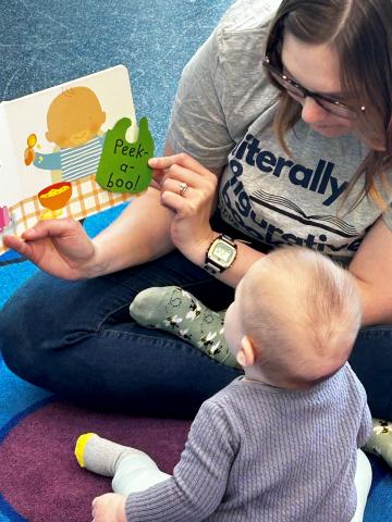 female adult reading to a baby