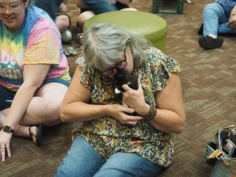 Woman holding black kitten