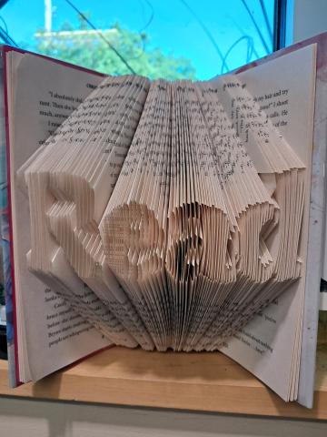 Book folded with pages forming the word "Read"