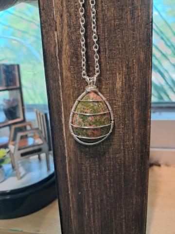 Green stone wire-wrapped and hung from a silver chain