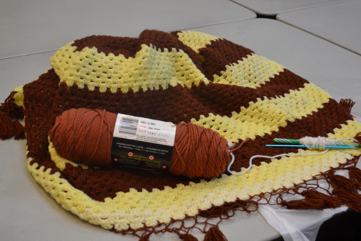 Brown skein of yarn on top of an in-progress fiber project